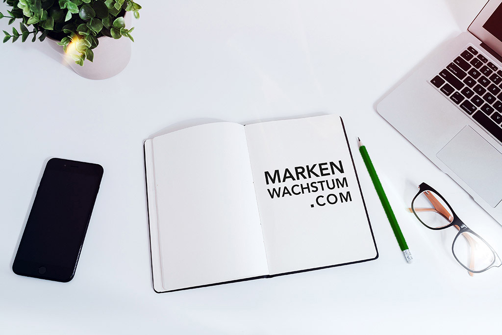 MARKENWACHSTUM Arbeitsplatz mit Notizbuch